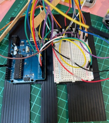 Black corrugated polypropylene base with two notches cut at the back, an Arduino UNO and a breadboard wired up on top