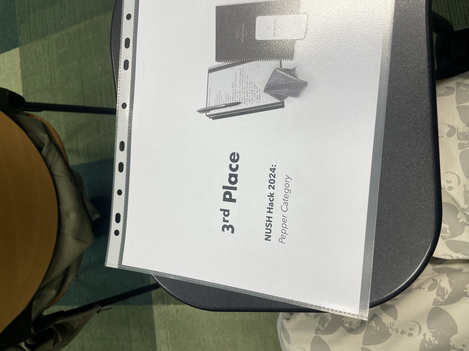 A printed certificate in a plastic sleeve reading 3rd Place, NUSH Hack 2024: Pepper Category